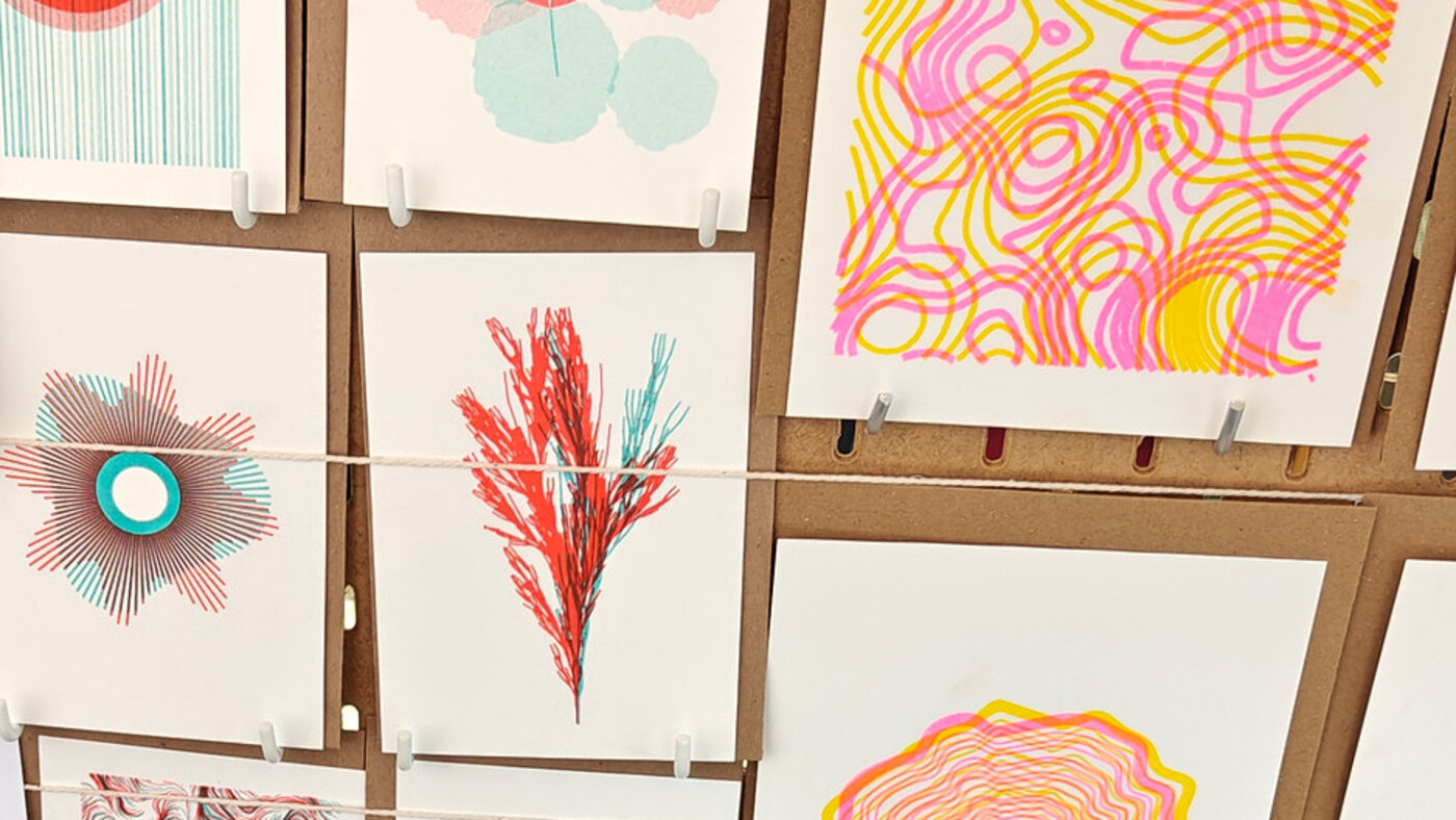 Risograph prints on a pegboard at the Abstract Threads market stall